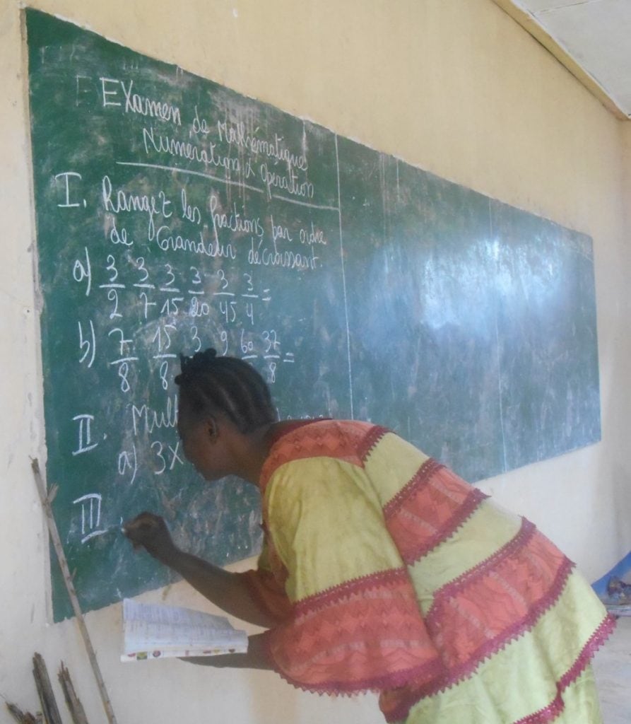 A teacher in Gemena writes an exam in classroom constructed with Covenant Kids Congo funds.